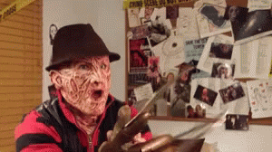 A Man Dressed As Freddy Krueger Holding A Knife GIF