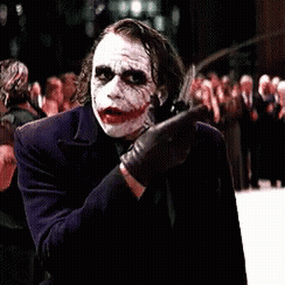 A Man Dressed As The Joker Is Standing In Front Of A Crowd Of People GIF