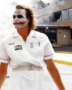 A Man Dressed As The Joker Is Wearing A White Shirt That Says " Dent " On It GIF