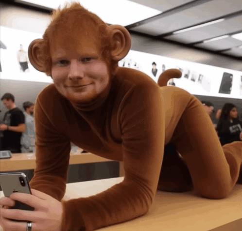 A Man Dressed In A Monkey Costume Holds A Cell Phone GIF
