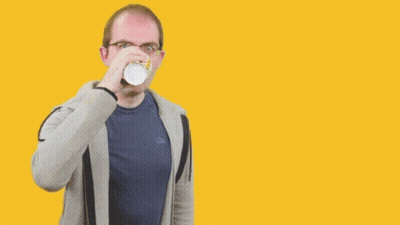 A Man Drinking From A Cup In Front Of A Yellow Background That Says " Stay Focused " GIF