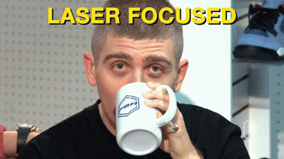 A Man Drinking From A Mug That Says Laser Focused On The Bottom GIF