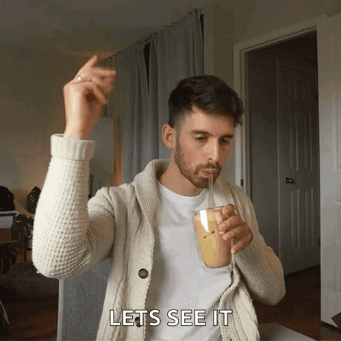 A Man Drinking Through A Straw With The Words Lets See It Behind Him GIF