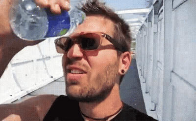 A Man Drinking Water From A Bottle While Wearing Sunglasses . GIF