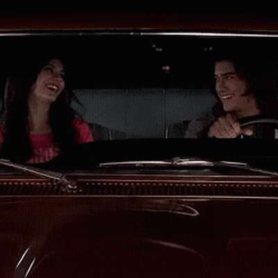 A Man Driving A Car With A Woman Sitting In The Back Seat GIF