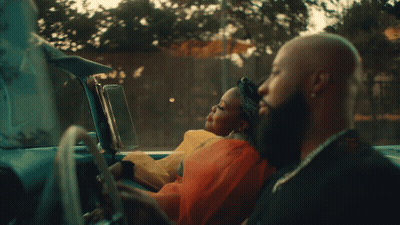 A Man Driving A Car With A Woman Sitting In The Back Seat GIF
