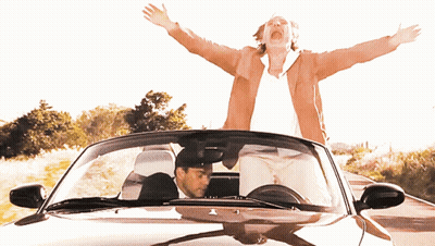 A Man Driving A Car With His Arms Outstretched GIF