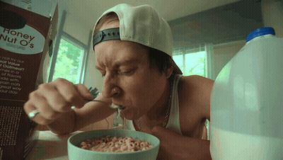 A Man Eats Honey Nut O 'S Cereal From A Bowl GIF