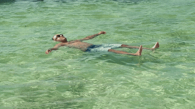 A Man Floating On His Back In The Water GIF