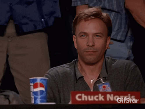 A Man Giving A Thumbs Up In Front Of A Sign For Chuck Norris GIF