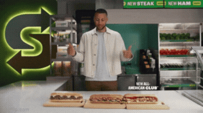 A Man Giving A Thumbs Up In Front Of Subway Sandwiches GIF
