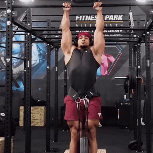 A Man Hangs Upside Down In Front Of A Fitness Park Sign GIF
