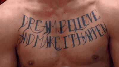 A Man Has A Tattoo On His Chest That Reads " Dream Believe And Make It Happen " GIF