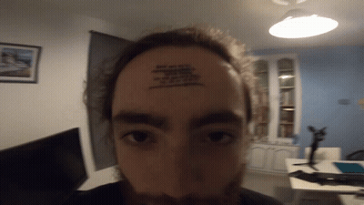 A Man Has A Tattoo On His Forehead That Says ' I Am A Fool ' GIF