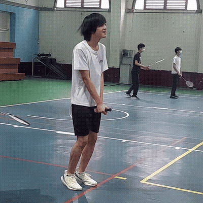 A Man Holding A Badminton Racquet On A Court GIF