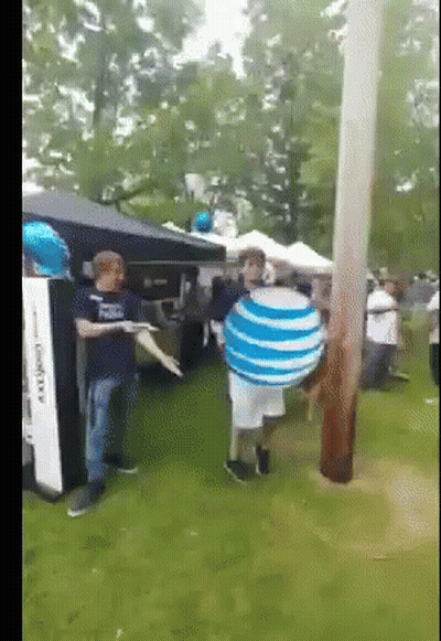 A Man Holding A Blue And White Striped Ball With The Word At & T On It GIF