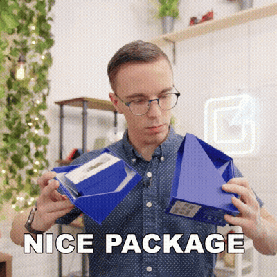 A Man Holding A Blue Box That Says Nice Package On The Bottom GIF