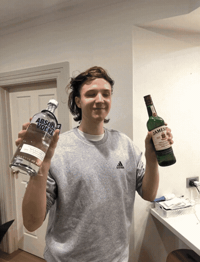 A Man Holding A Bottle Of Absolut Vodka Next To A Bottle Of Jameson GIF