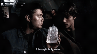 A Man Holding A Bottle That Says I Brought Holy Water On It GIF