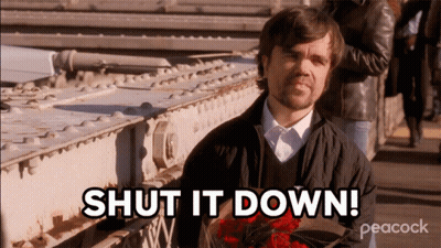 A Man Holding A Bouquet Of Red Roses With The Words Shut It Down Behind Him GIF