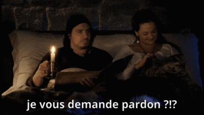 A Man Holding A Candle Next To A Woman Who Is Reading A Book With The Words Je Vous Demande Pardon Written Below Them GIF