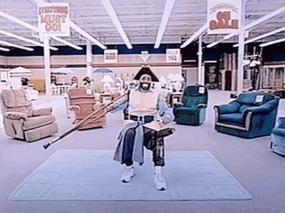 A Man Holding A Cane In A Store With A Sign That Says " Must Go " GIF