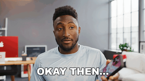 A Man Holding A Cell Phone With The Words Okay Then Written On His Shirt GIF