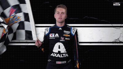 A Man Holding A Checkered Flag Wearing A Shirt That Says Axalta On It GIF