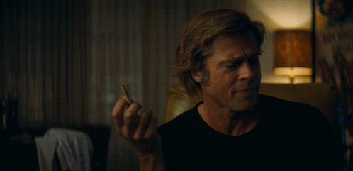 A Man Holding A Cigarette In Front Of A Sign That Says " Why Not " GIF