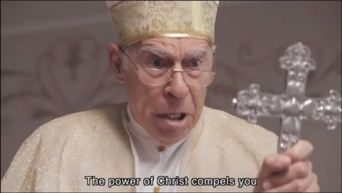 A Man Holding A Cross With The Words " The Power Of Christ Compels You " Below Him GIF