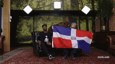 A Man Holding A Dominican Flag Next To A Bear GIF