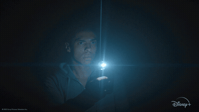 A Man Holding A Flashlight In A Dark Room With A Disney + Logo GIF