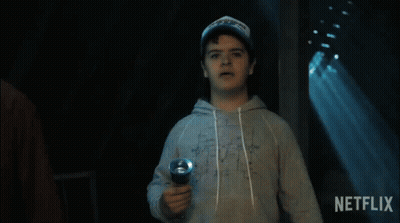 A Man Holding A Flashlight With A Netflix Logo In The Background GIF
