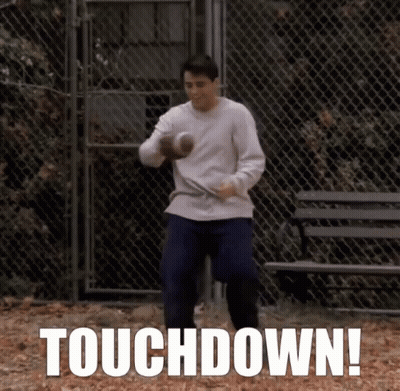 A Man Holding A Football In Front Of A Chain Link Fence With The Words Touchdown Written On The Bottom GIF