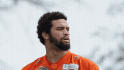 A Man Holding A Football With A Name Tag That Says Advocacy Health Care GIF