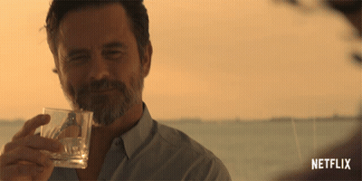 A Man Holding A Glass With A Netflix Logo In The Corner GIF