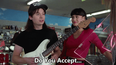 A Man Holding A Guitar Next To A Woman With The Words Do You Accept GIF