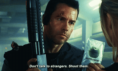 A Man Holding A Gun And A Packet Of Supplements Says " Don 'T Talk To Strangers Shoot Them " GIF