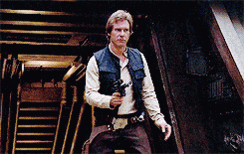 A Man Holding A Gun In A Dark Room With Stairs In The Background GIF