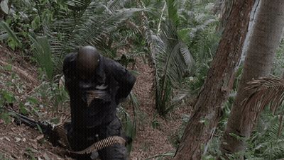 A Man Holding A Gun In A Jungle With The Words I 'M Gonna Have Me Some Fun Below Him GIF