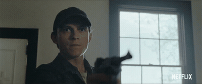 A Man Holding A Gun In Front Of A Window With Netflix Written On The Bottom Right GIF