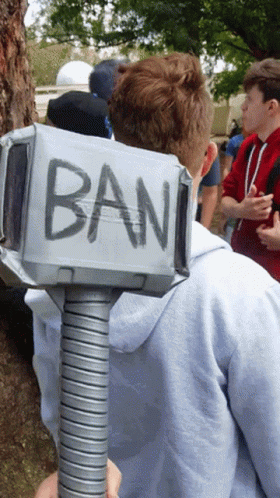 A Man Holding A Hammer That Has The Word Ban Written On It GIF