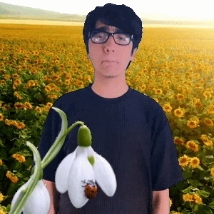 A Man Holding A Ladybug And A Flower In Front Of A Field Of Flowers GIF