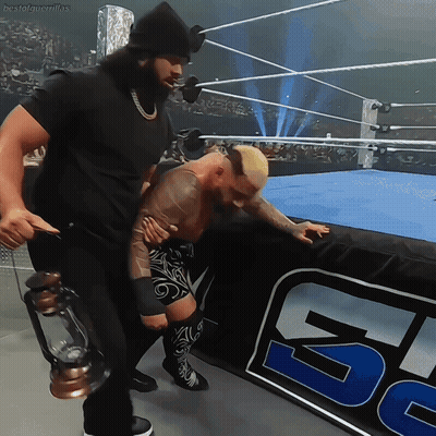 A Man Holding A Lantern Stands Next To A Wrestler In A Ring GIF