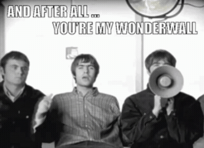 A Man Holding A Megaphone With The Words And After All You 'Re My Wonderwall Above Him GIF
