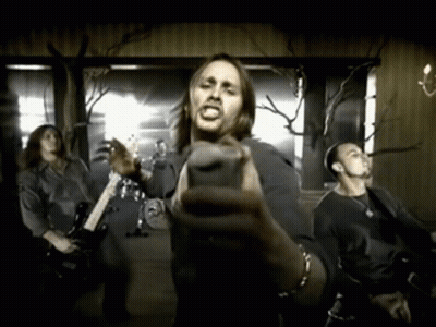A Man Holding A Microphone In Front Of A Group Of People GIF