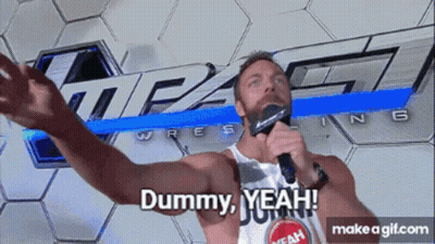 A Man Holding A Microphone In Front Of A Sign That Says Impact Wrestling GIF