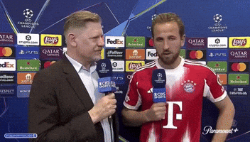 A Man Holding A Microphone Next To A Man In A T-Mobile Shirt GIF