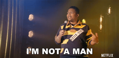 A Man Holding A Microphone Says " I 'M Not A Man " On Stage GIF