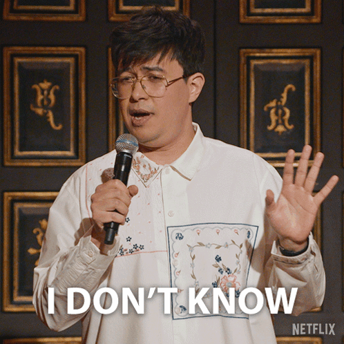 A Man Holding A Microphone With The Words I Don 'T Know On His Shirt GIF